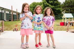 Three school agers wearing tie-dye shirts
